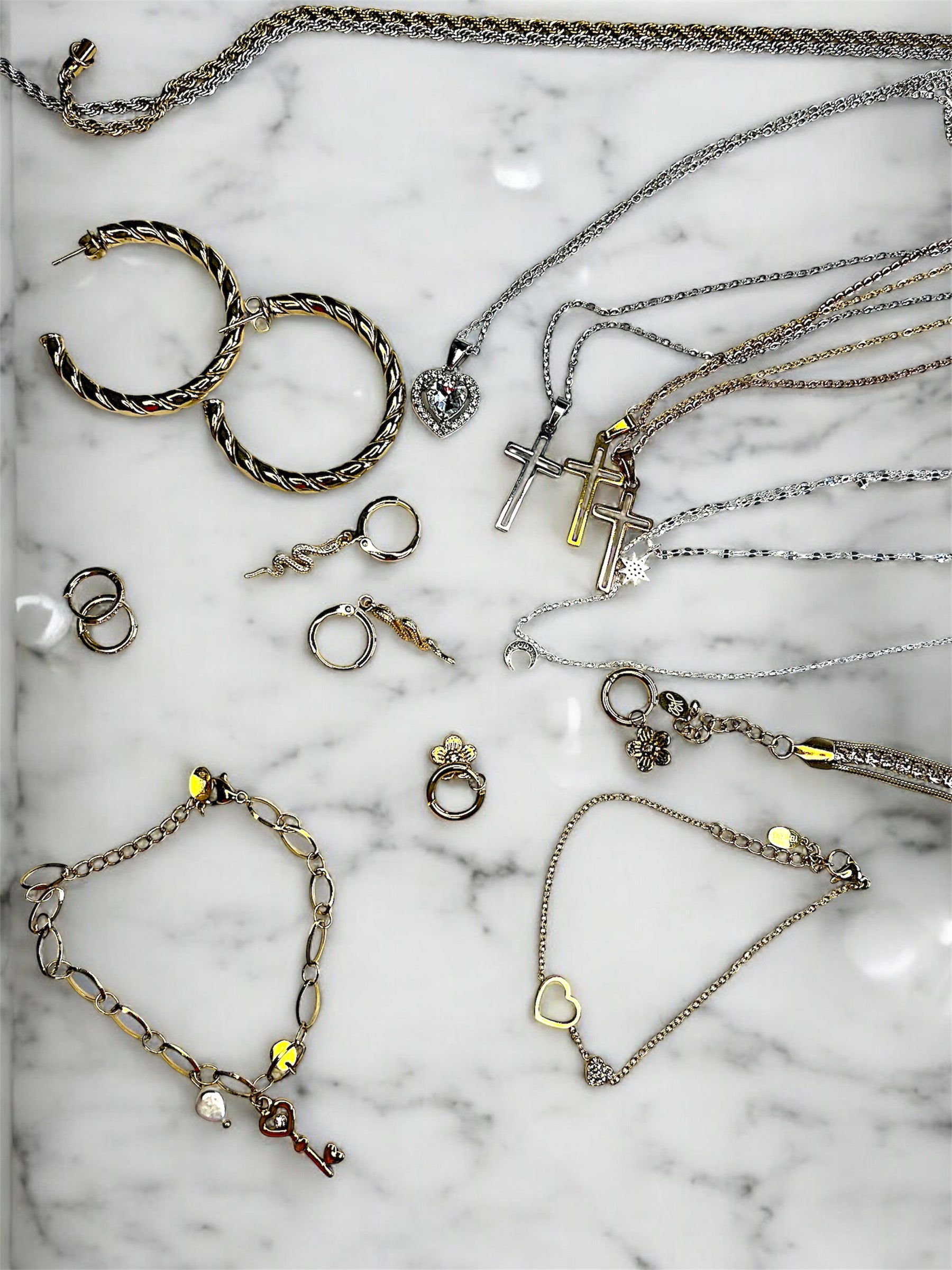 Luxurious jewelry pieces from Luminove Jewelry displayed on an elegant marble surface – waterproof, made from stainless steel and sterling silver, durable, timelessly designed, and affordable luxury for any occasion