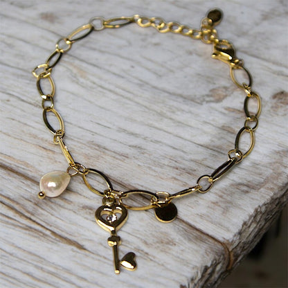 Stylish waterproof bracelet made of gold-plated stainless steel, featuring a key charm and a delicate pearl detail. Durable and elegant, perfect for everyday wear and special occasions.